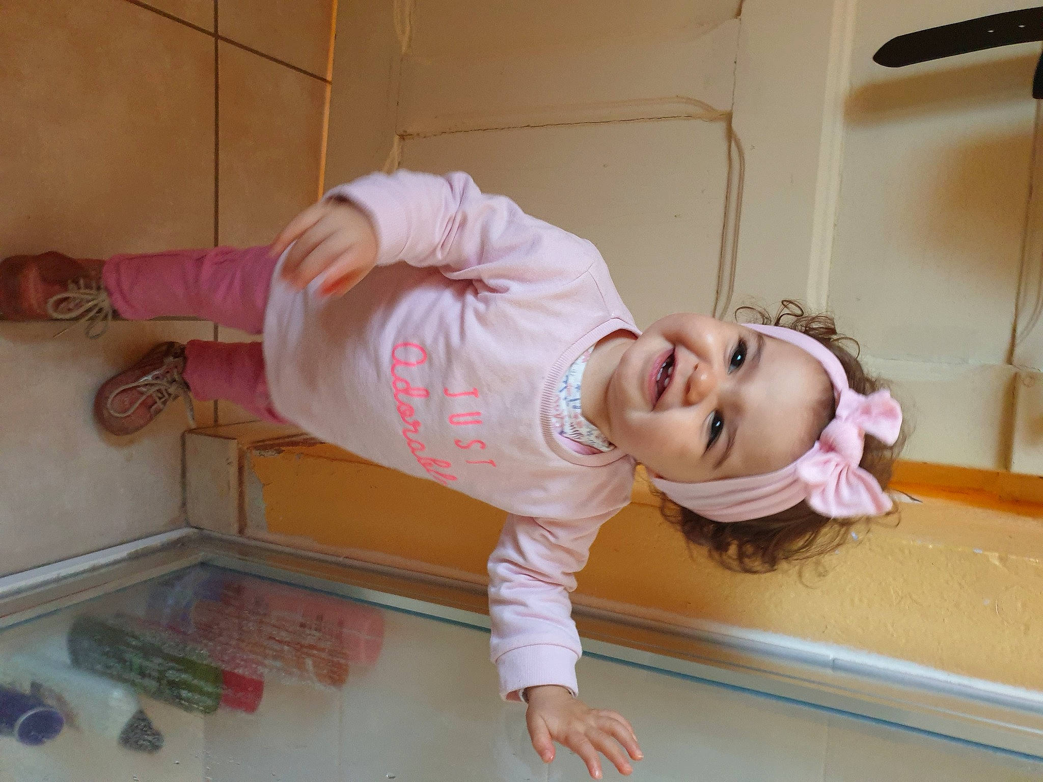 Elise participe au concours pour gagner de l'argent avec cette photo : baby_toddler_clothing, child, comfort, drawer, eyewear, floor, flooring, fun, happy, headwear, human_leg, joy, knee, person, pink, room, sleeve, smile, sunglasses, t_shirt