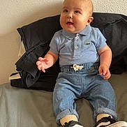 Gabin participe au concours pour gagner de l'argent avec cette photo : baby, child, polo_shirt, denim_pants, sitting, bed, shoes, black_shoes, white_shoes, curious, happy, indoor, casual_clothing, infant, cute, person, smiling, wall, textured_wall, comfortable