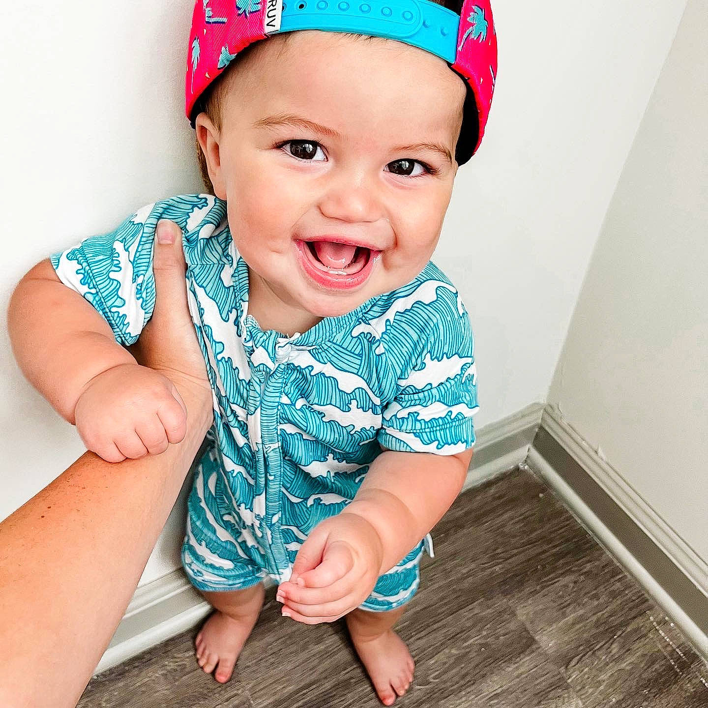 Radley is registered to the contest to win money with this photo: arm, azure, baby, baby_toddler_clothing, blue, cap, child, clothing, cool, electric_blue, facial_expression, happy, head, headwear, joy, neck, person, pink, skin, sleeve