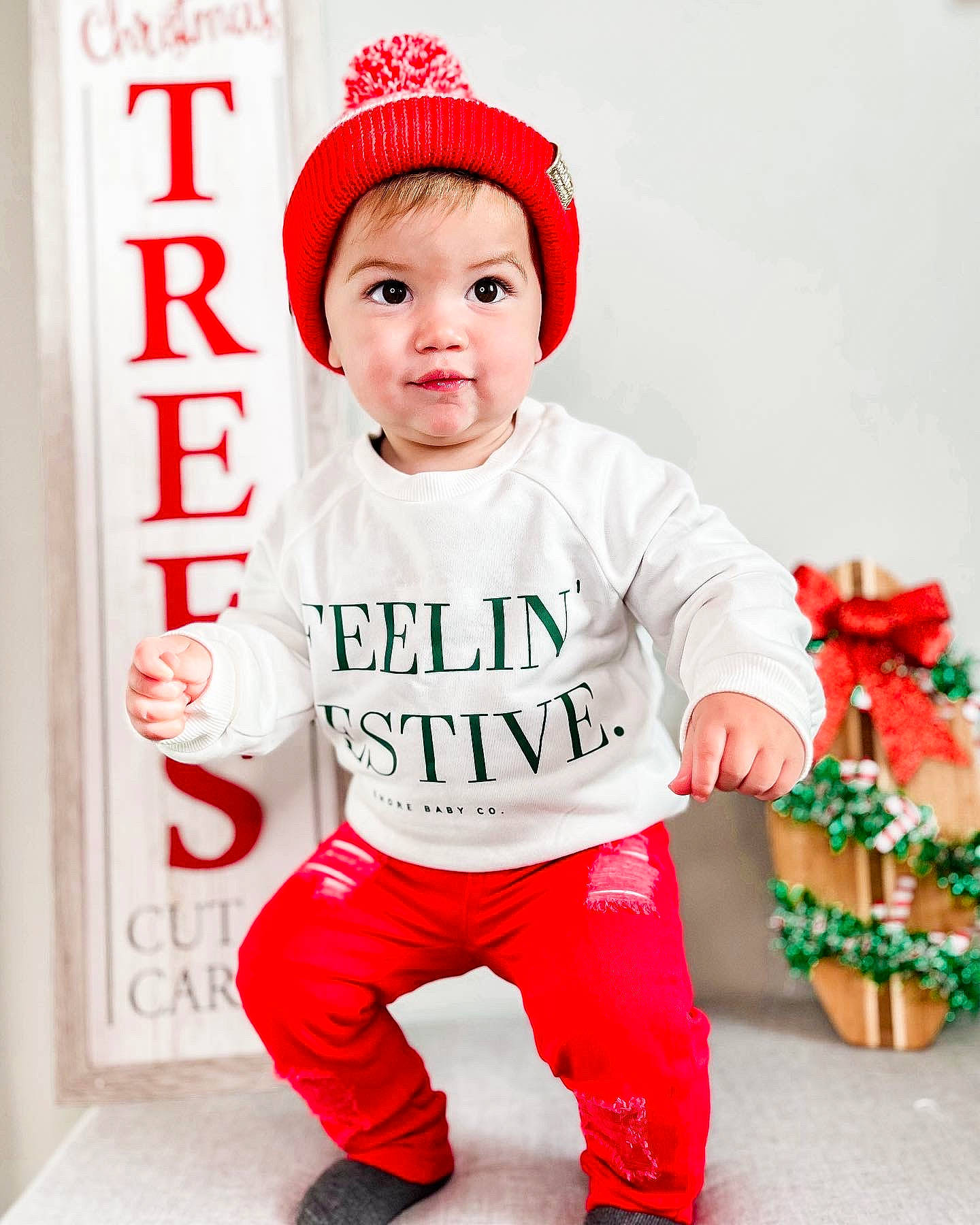Radley is registered to the contest to win money with this photo: baby, baby_toddler_clothing, cap, child, clothing, costume_hat, facial_expression, fictional_character, font, happy, headwear, holiday, outerwear, pattern, person, pink, product, red, sleeve, t_shirt