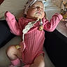 Taytum is registered to the contest to win money with this photo: baby, sleeping, pink_onesie, headband, pacifier, socks, legs, white_surface, floral_pattern, fabric, infant, cute, resting, child, young_baby, hands, closeup, indoor, comfort, soft