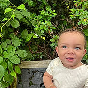 Eris G Hall joined the competition — help win amazing prizes! baby, child, smiling, outdoor, greenery, bench, leaf, curly_hair, cute, nature, plant, portrait, happy, toddler, skin, white_clothing, bracelet, sunlight, garden, face