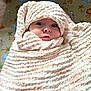 baby, blanket, wrapped, soft_texture, face, wide_eyes, infant, cozy, cute, expression, indoor, animal_pattern, nursery, child, portrait, warm, head, snug, newborn, curious