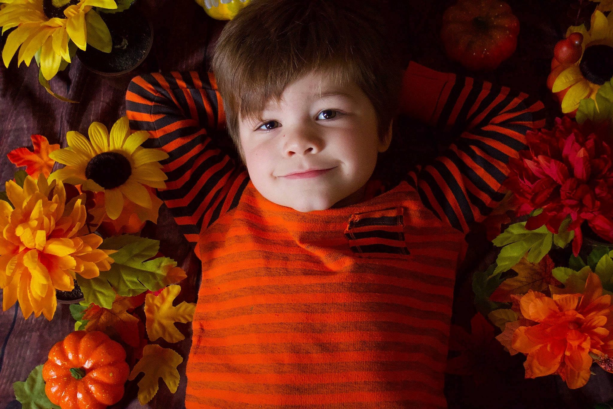 Jaxon is registered to the contest to win money with this photo: annual_plant, baby_toddler_clothing, child, facial_expression, flower, flower_arranging, flowering_plant, grass, happy, iris, joy, leaf, orange, people_in_nature, person, petal, plant, spring, toddler, tree
