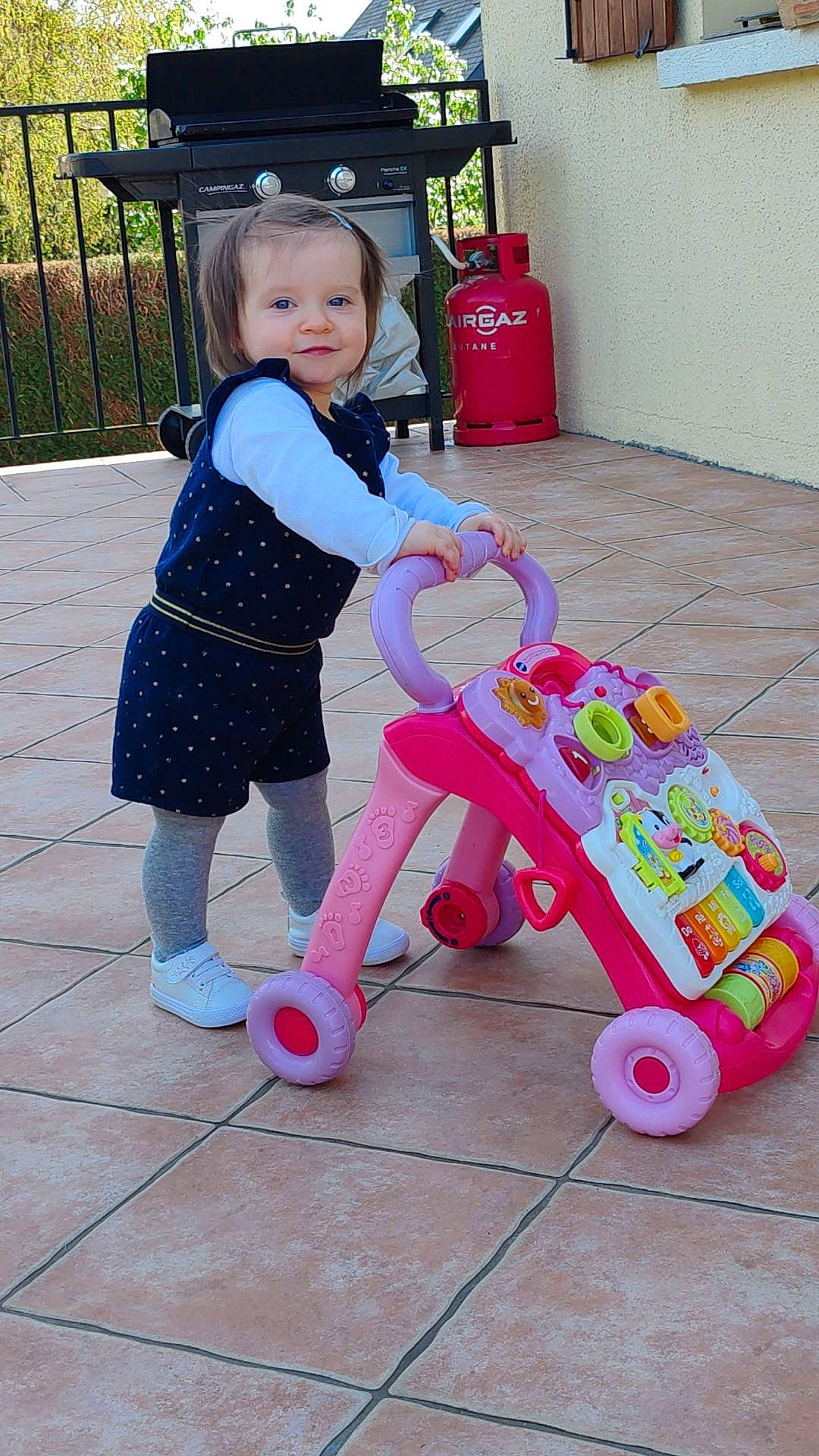 Mya a rejoint le concours — aidez-le/la à gagner de superbes lots ! baby, baby_playing_with_toys, baby_products, baby_toddler_clothing, baby_toys, child, fun, happy, joy, magenta, person, pink, plant, play, riding_toy, shelf, smile, tire, toddler, toy