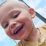 child, smiling, closeup, face, yellow_shirt, sun_pattern, outdoor, sky, blue_sky, happy, cute, young, play_area, mesh, portrait, childhood, cheerful, casual_clothing, daylight, person