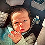 Yésiah is registered to the contest to win money with this photo: baby, infant, car_seat, blanket, child, face, hand, curious, indoors, seatbelt, soft_texture, sunlight, closeup, young_child, person, cute, expression, hair, clothing, safety