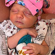 Elena is registered to the contest to win money with this photo: newborn, baby, sleeping, headband, pink, bow, pacifier, plush_toy, giraffe, blanket, floral, cute, infant, hand, face, clothing, resting, indoors, person, soft