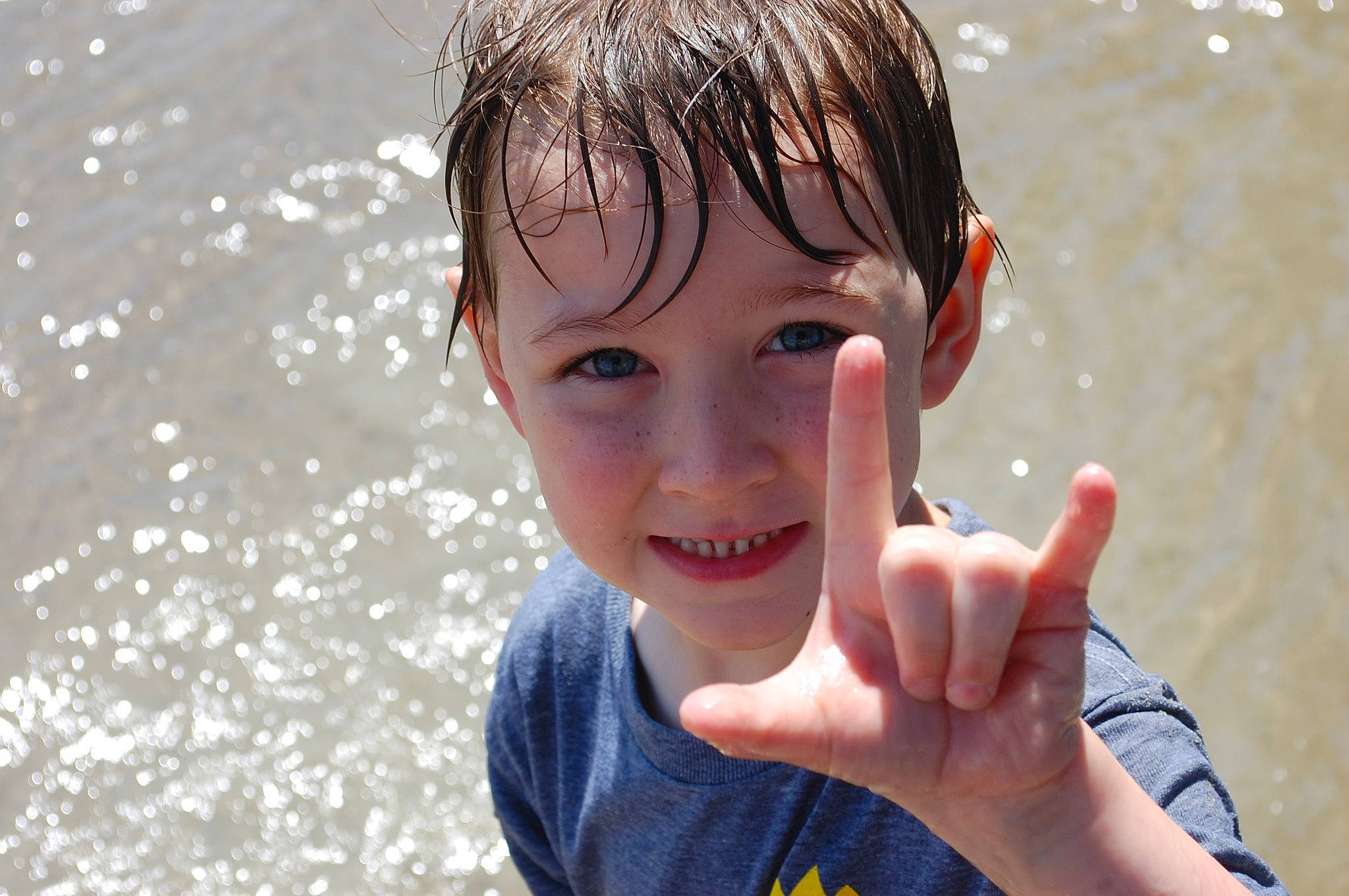 Max is registered to the contest to win money with this photo: arm, bathing, body_of_water, chin, eye, flash_photography, gesture, hand, happy, headwear, human_body, joy, leisure, nose, people_in_nature, people_on_beach, person, recreation, skin, smile