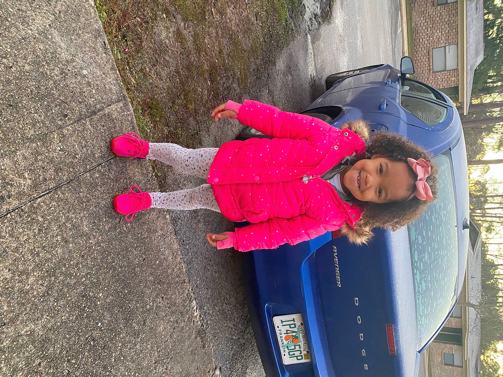 Kyleigh is registered to the contest to win money with this photo: asphalt, automotive_exterior, automotive_lighting, car, child, electric_blue, fun, joy, motor_vehicle, pedestrian, person, plant, road_surface, sidewalk, smile, tire, toddler, travel, tree, vehicle