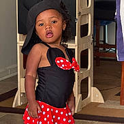Khonstanz joined the competition — help win amazing prizes! black_top, casual_pose, child, curly_hair, cute, earrings, expression, floor, girl, hat, home, indoor, person, playful_outfit, polka_dot, red_skirt, standing, toddler, wooden_furniture, young