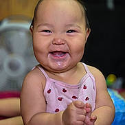 Lily is registered to the contest to win money with this photo: baby, child, smiling, happy, indoor, face, person, cute, pink_clothing, ladybug_pattern, chubby_cheeks, sitting, infant, joyful, closeup, skin, head, arms, hands, expression