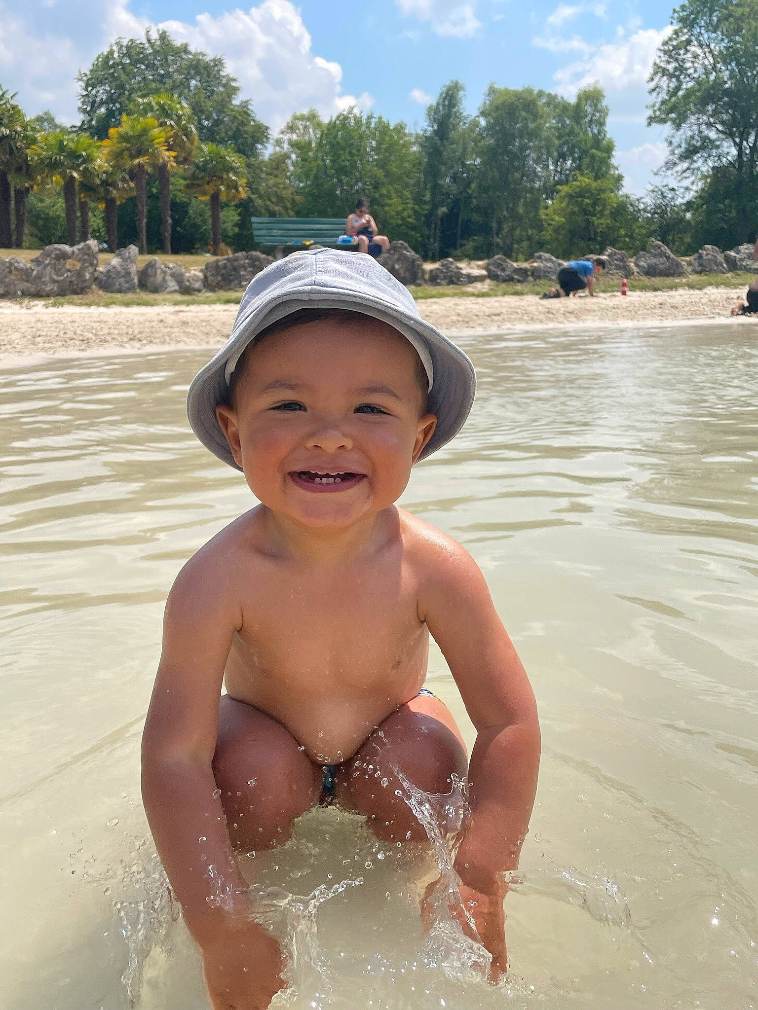 Sylann participe au concours pour gagner de l'argent avec cette photo : bathing, beach, chest, cloud, fun, happy, hat, headwear, joy, lake, leisure, people_on_beach, person, personal_protective_equipment, recreation, sky, smile, summer, swimwear, toddler