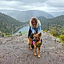 Savio participe au concours pour gagner de l'argent avec cette photo : person, dog, german_shepherd, mountain, lake, forest, rocks, outdoor, nature, cloudy_sky, glasses, smiling, pet, animal, hiking, landscape, scenic, fence, tongue_out, happy