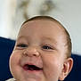 baby, smiling, close_up, face, drool, happy, infant, child, cute, blue_eyes, skin, head, expression, joyful, indoors, portrait, young, person, background_blur, clothing