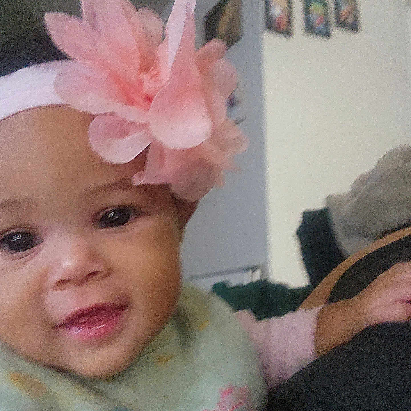 Paulaina is registered to the contest to win money with this photo: apparel, baby, blurred_background, child, clothing, cute, decoration, face, flower, hand, happy, headband, indoors, infant, person, pink, portrait, smile, wall, young