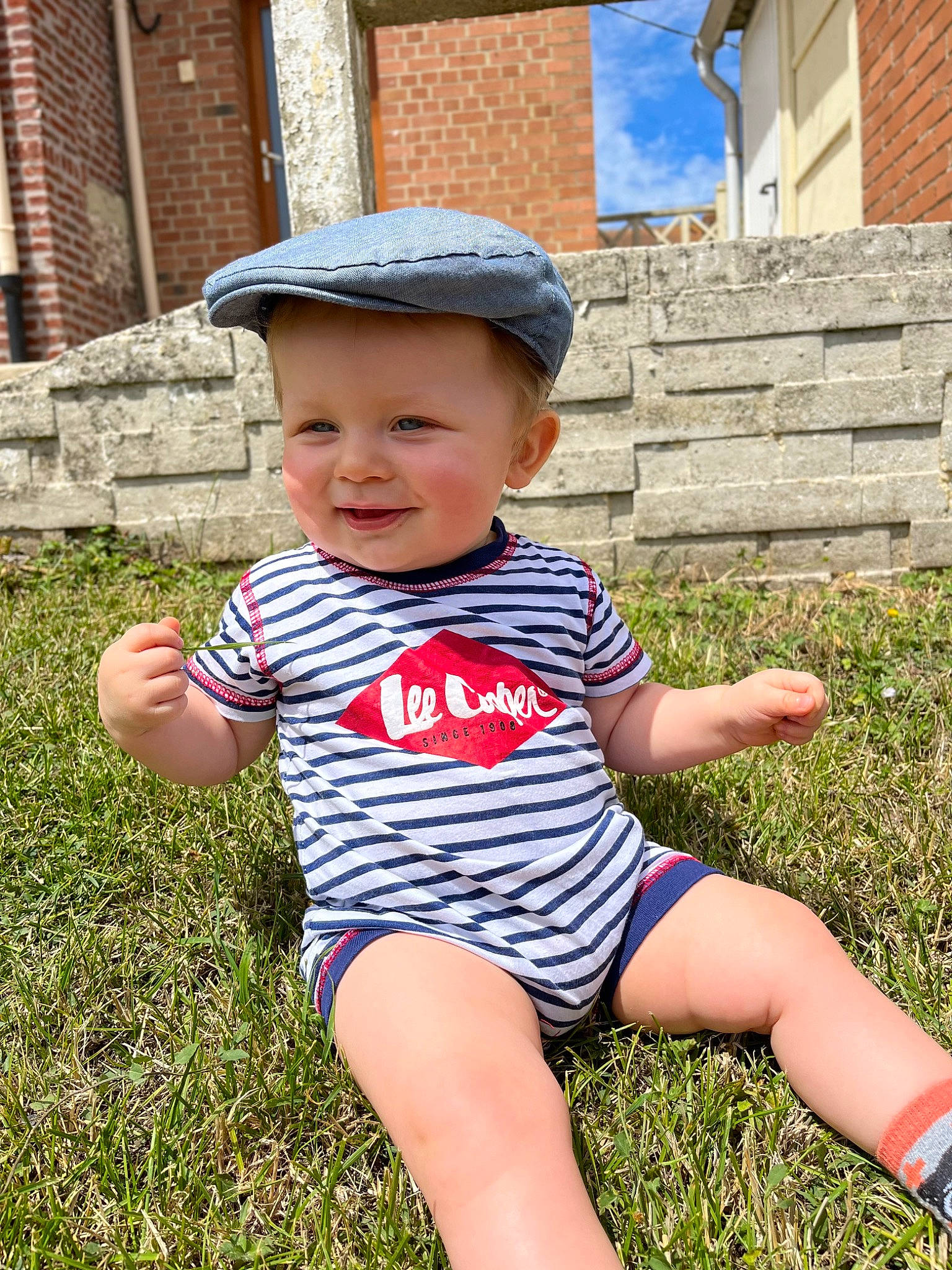 Axel a rejoint le concours — aidez-le/la à gagner de superbes lots ! baby, baby_toddler_clothing, blue, electric_blue, finger, fun, grass, happy, hat, headwear, joy, leg, leisure, people_in_nature, person, plant, smile, standing, summer, sun_hat