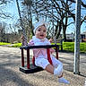 Loëlya participe au concours pour gagner de l'argent avec cette photo : baby, bench, bib, blue_sky, bow, chain, grass, headband, infant, outdoor, park, pavement, playground, shoe, smiling, socks, sunlight, swing, toddler, trees