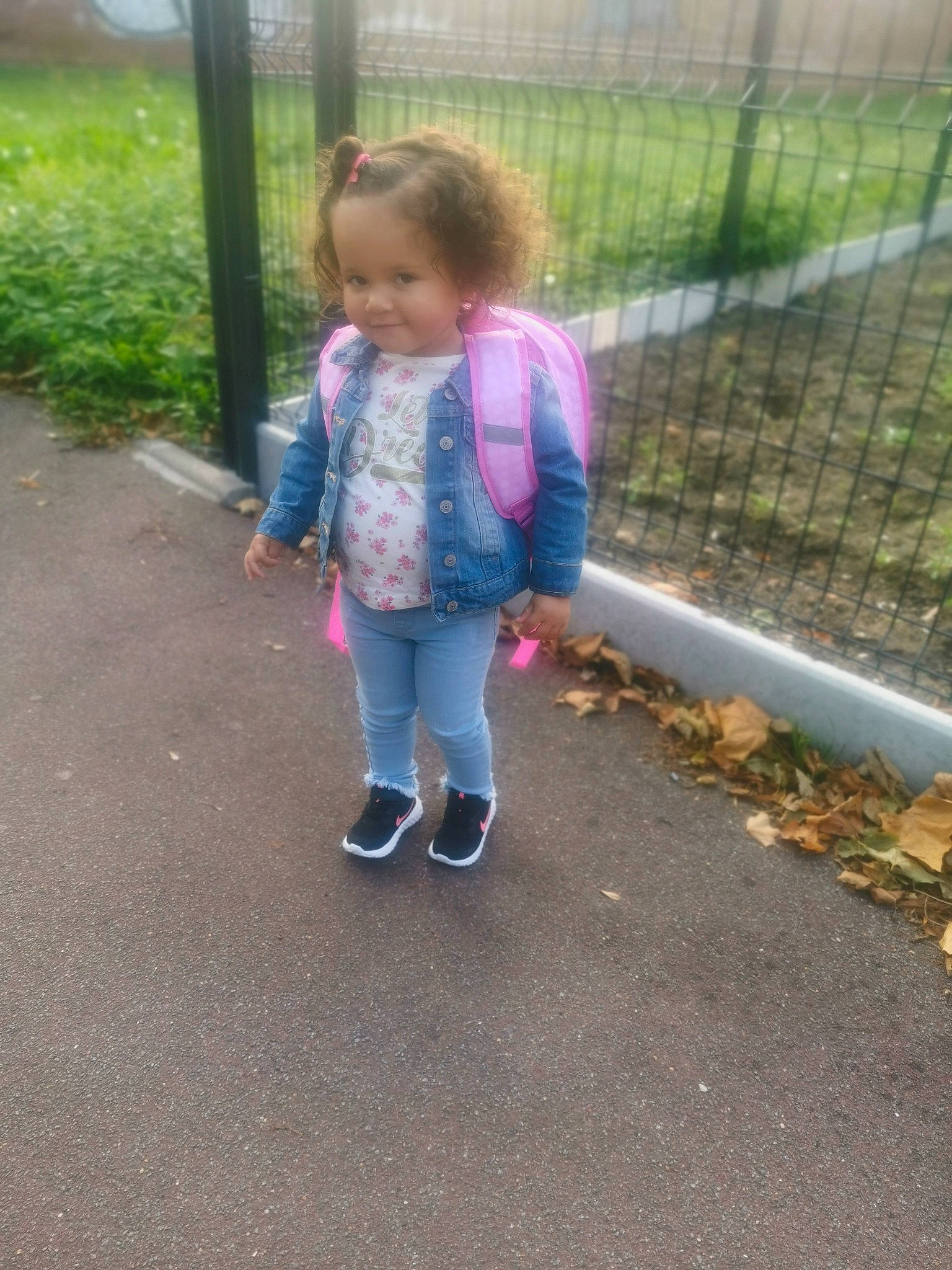 Maïssa a rejoint le concours — aidez-le/la à gagner de superbes lots ! asphalt, baby_toddler_clothing, child, fence, fun, grass, happy, head, home_fencing, joy, leisure, magenta, mesh, person, plant, recreation, road_surface, sidewalk, smile, toddler