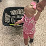 Andréa-Jade joined the competition — help win amazing prizes! toddler, child, shopping_basket, store, floor, hand_holding, pink_bow, pink_clothing, shorts, shoes, adult_hand, person, shopping_cart, aisle, casual_clothing, indoor, retail, cartoon_print, yellow_shirt, green_shorts