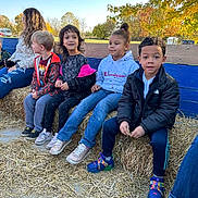 Raelynn is registered to the contest to win money with this photo: children, kids, hay_bales, fall, autumn, outdoor, trees, jackets, sneakers, grass, blue_sky, bench, playful, friends, casual, smiling, nature, daylight, leaves, group