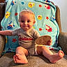 Grayson joined the competition — help win amazing prizes! armchair, baby, barefoot, blanket, cardinals, child, colorful, cozy, fish_pattern, gray_clothing, happy, indoors, living_room, portrait, sitting, smiling, sports_shirt, toddler, toy, wooden_sign