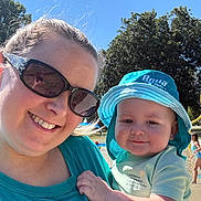 Grayson joined the competition — help win amazing prizes! adult, baby, child, selfie, smiling, outdoor, pool, sunny, summer, sun_hat, turquoise_clothing, sunglasses, mother, infant, portrait, family, trees, blue_sky, water, playground