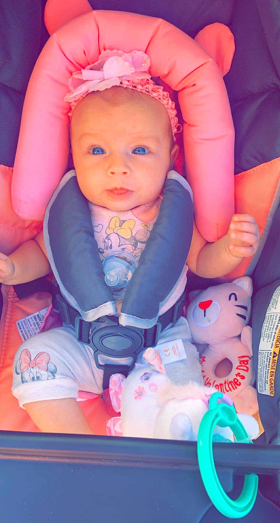 Alyson is registered to the contest to win money with this photo: arm, baby, baby_carriage, baby_toddler_clothing, cheek, comfort, eyebrow, eyelash, finger, happy, mouth, nail, orange, person, pink, product, purple, red, skin, toddler