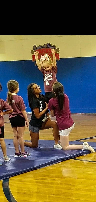 Alexis Lower is registered to the contest to win money with this photo: championship, cheerleading, competition, competition_event, event, fun, joy, leisure, mat, person, player, recreation, shorts, sneakers, sports, sports_uniform, sportswear, t_shirt, team_sport, thigh