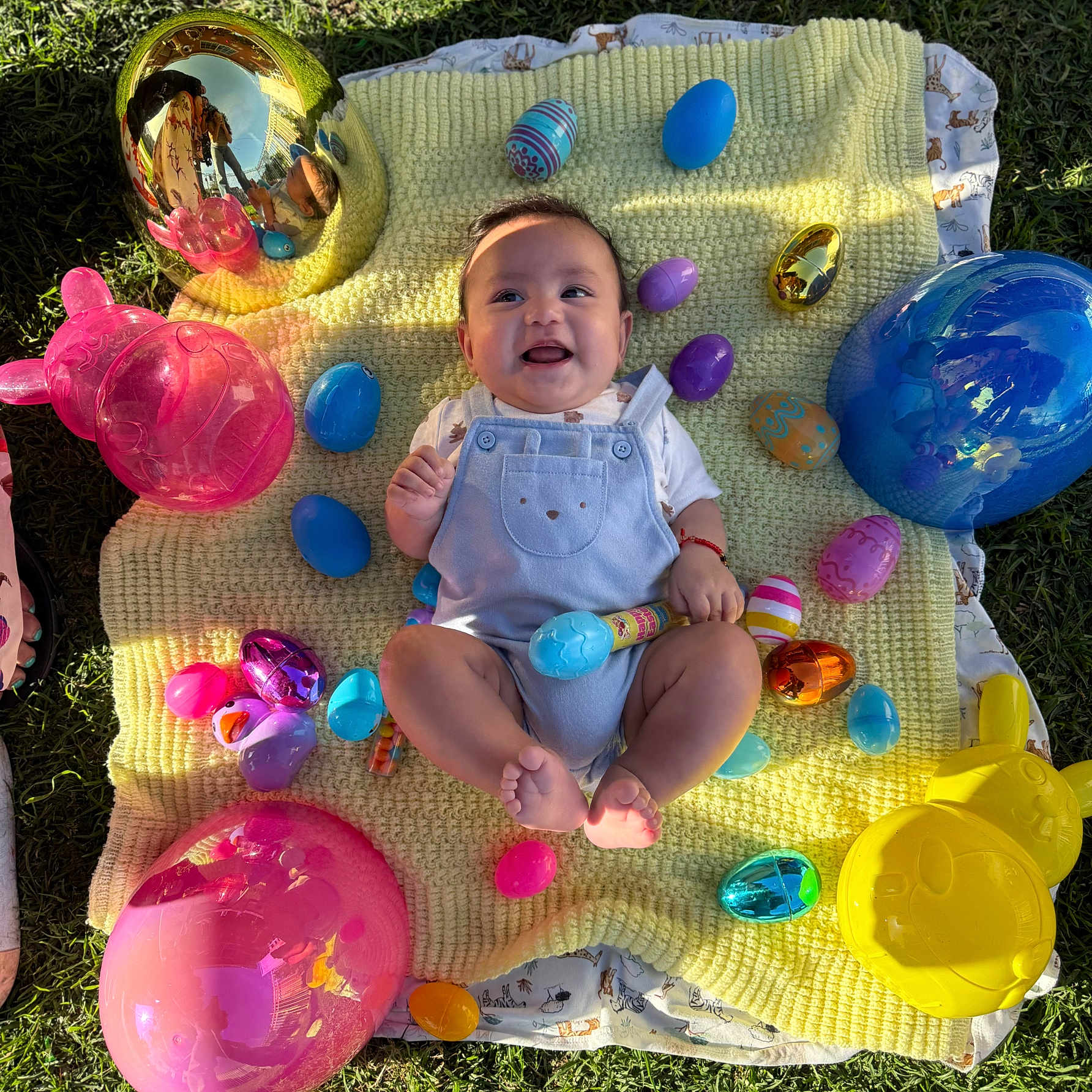 Marcos is registered to the contest to win money with this photo: baby, balloons, blue_onesie, celebration, child, colorful, cute, easter_eggs, festive, grass, happy, holiday, outdoor, playful, sitting, smiling, spring, sunlight, toy, yellow_blanket