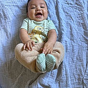 Marcos joined the competition — help win amazing prizes! baby, smiling, infant, lying_down, blanket, striped_clothing, cartoon_print, socks, happy, cute, child, portrait, indoors, soft_texture, cozy, small_hands, feet, young_child, playful, comfortable