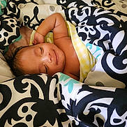 Aarthik joined the competition — help win amazing prizes! baby, sleeping, blanket, patterned_blanket, cozy, smile, child, infant, resting, cute, wrapped, soft, comfort, indoor, peaceful, portrait, human, skin, head, relaxation