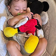 Ky'Son is registered to the contest to win money with this photo: baby, infant, sleeping, pacifier, stuffed_toy, mickey_mouse, plush, baby_seat, cushion, blanket, curly_hair, barefoot, indoor, child, cute, relaxed, soft_lighting, comfortable, resting, toy