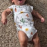 Ky'Son is registered to the contest to win money with this photo: baby, infant, carpet, onesie, clothing, patterned_clothing, cactus, sun, lying_down, expression, surprised, face, skin, barefoot, person, child, indoors, floor, cute, young