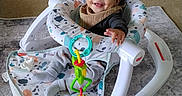Ky'Son joined the competition — help win amazing prizes! baby, child, smiling, baby_walker, toy, indoor, carpet, bib, clothing, happy, face, curly_hair, seat, playtime, infant, person, floor, home, baby_toy, young_child