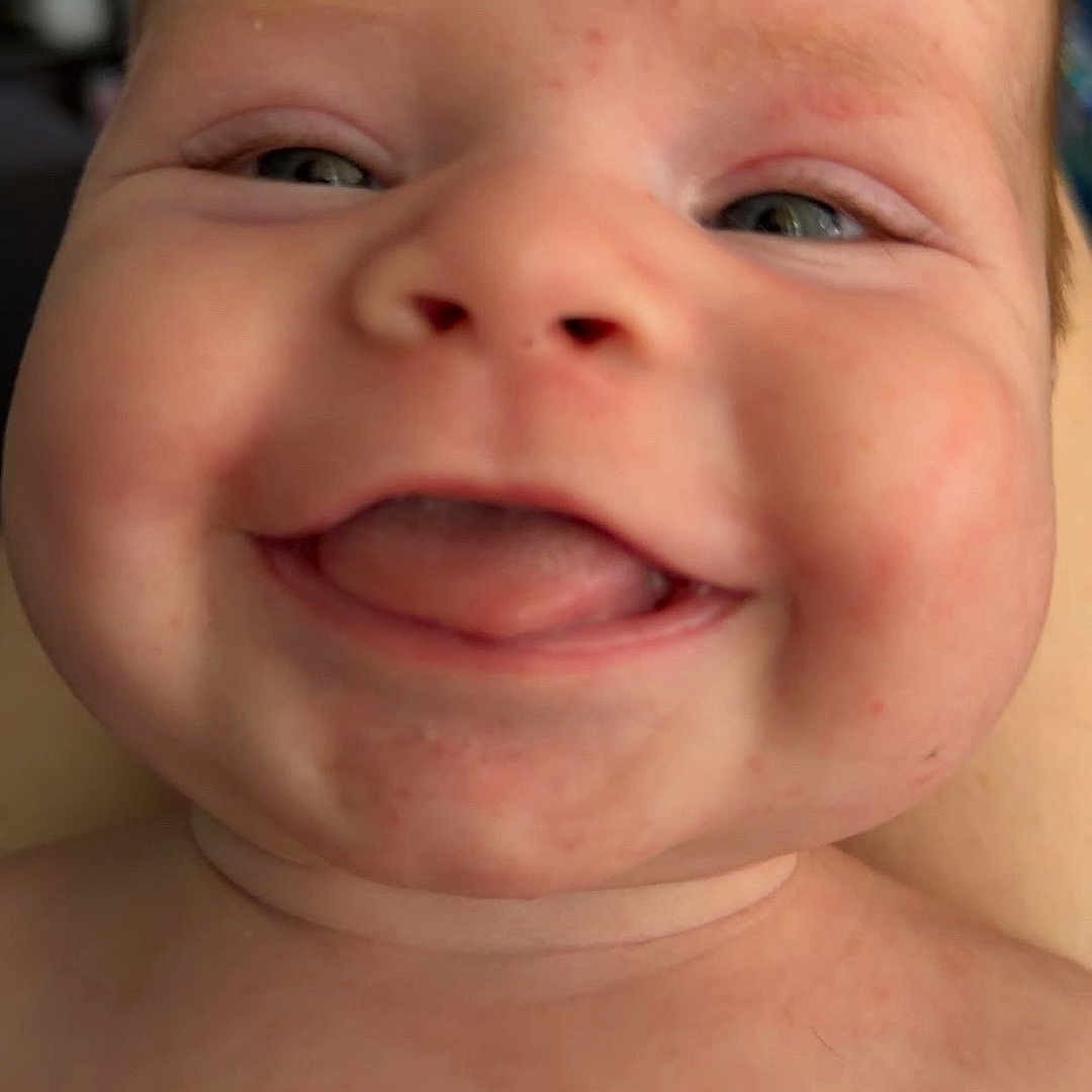 Brooks joined the competition — help win amazing prizes! baby, close_up, smiling, tongue_out, chubby_cheeks, face, skin, head, infant, portrait, happy, cute, child, human, expression, eyes, mouth, indoors, blurred_background, skin_texture