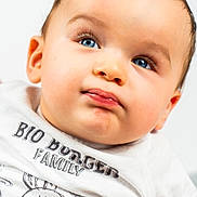 Maël participe au concours pour gagner de l'argent avec cette photo : baby, baby_fashion, blue_eyes, cartoon, child, close_up, clothing, cute, expression, face, hair, head, infant, person, portrait, shirt, skin, smile, white_background, young