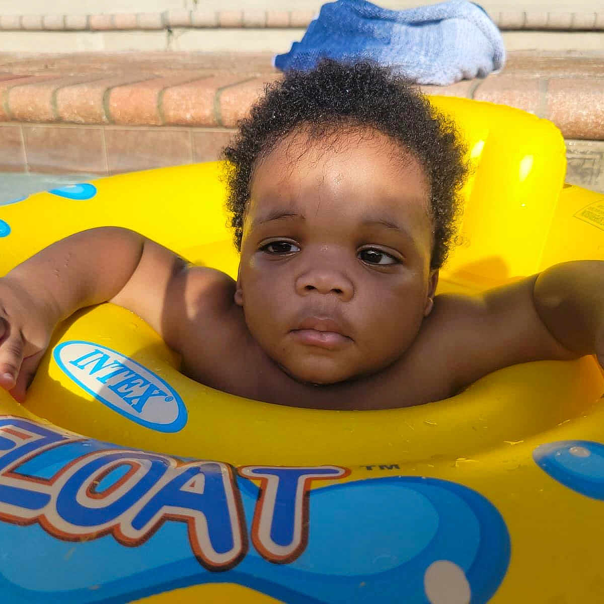 Jevaughn is registered to the contest to win money with this photo: baby, child, curly_hair, float, fun, infant, outdoor, play, pool, relaxation, shadow, skin, steps, summer, sunlight, swimming, toddler, towel, water, yellow