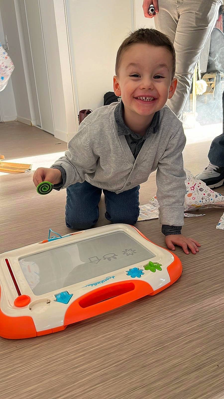 Ezra participe au concours pour gagner de l'argent avec cette photo : automotive_design, baby, baby_toddler_clothing, carmine, child, cleanliness, door, floor, flooring, fun, gadget, joy, person, plastic, play, room, sitting, smile, toddler, toy_vehicle
