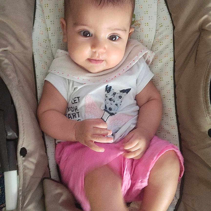 Ons a rejoint le concours — aidez-le/la à gagner de superbes lots ! baby, baby_chair, carpet, cat_print, child, curious_expression, cushion, cute, indoor, infant, kicking_leg, looking_at_camera, one_person, pink_shorts, portrait, relaxed, seat, soft_fabric, white_shirt, young_child