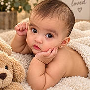 Ameliana is registered to the contest to win money with this photo: baby, infant, child, portrait, face, eyes, smiling, sitting, lying_down, blanket, teddy_bear, stuffed_animal, nursery, flowers, indoor, cozy, warm_lighting, earring, brown_hair, photography