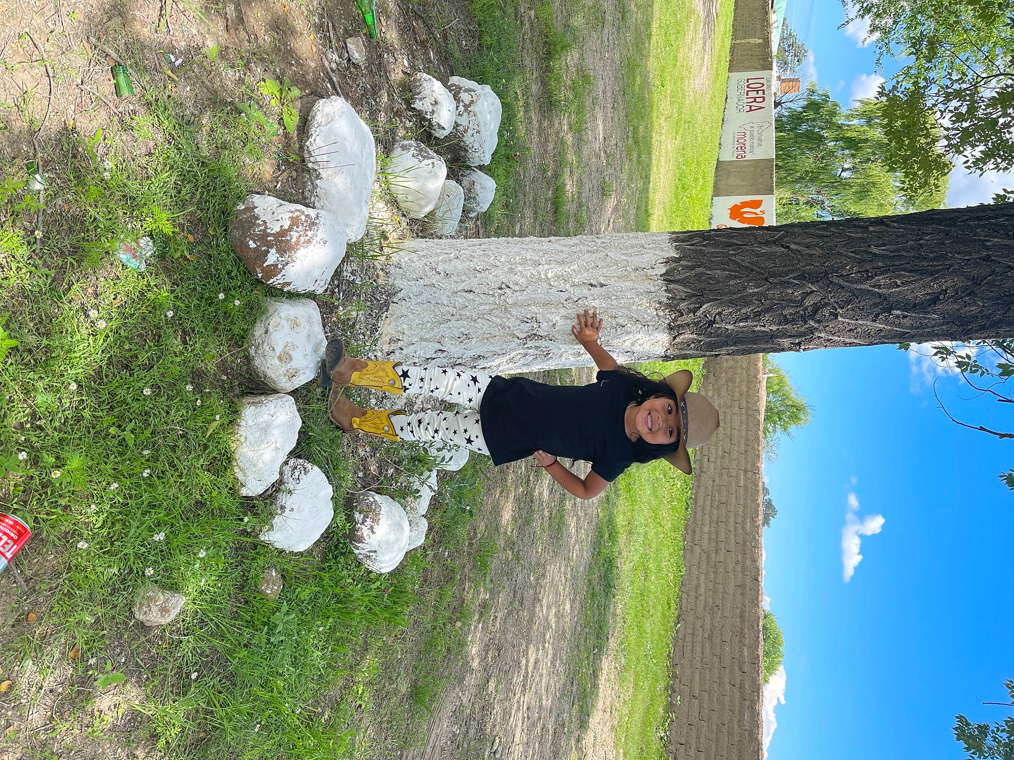 Layla Naomii is registered to the contest to win money with this photo: biome, botany, branch, fun, grass, groundcover, headwear, joy, landscape, leaf, leisure, natural_environment, organism, people_in_nature, person, plant, recreation, sky, tree, trunk