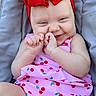 Loralie is registered to the contest to win money with this photo: baby, infant, child, red_headwrap, pink_outfit, cherry_pattern, cute_expression, smiling, hands, face, skin, sitting, cushion, gray_background, closeup, portrait, happy, fashion, summer, outdoor