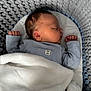 baby, newborn, sleeping, blanket, knitted_basket, infant, cozy, soft, blue_clothing, peaceful, portrait, child, resting, closeup, indoors, cute, toddler, sleepwear, warm, comfort