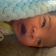 Raiden is registered to the contest to win money with this photo: baby, blanket, pacifier, face, infant, expression, indoor, soft, comfort, child, cute, newborn, lying_down, wrapped, window, light, head, skin, clothing, bed