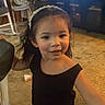 Athena is registered to the contest to win money with this photo: child, girl, headband, black_clothing, carpet, indoor, television, cartoon, smile, hair, furniture, toy, living_room, person, floor, seat, home, cute, young, casual