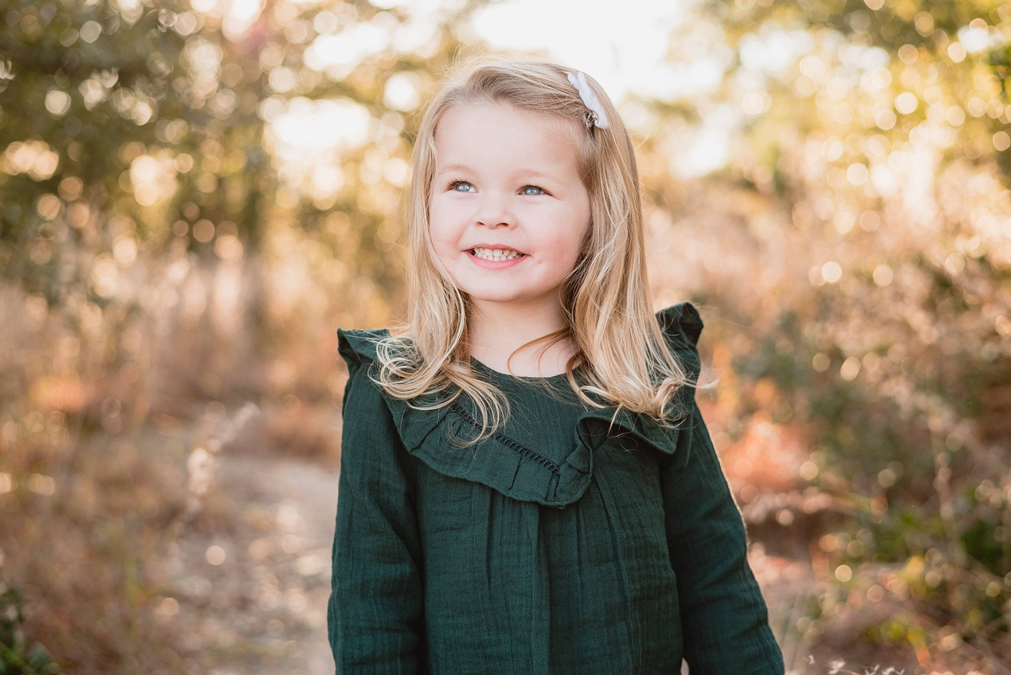 Addilyn is registered to the contest to win money with this photo: blond, branch, brown_hair, dress, face, flash_photography, forest, grass, happy, iris, joy, lip, long_hair, people_in_nature, person, plant, smile, street_fashion, sunlight, toddler