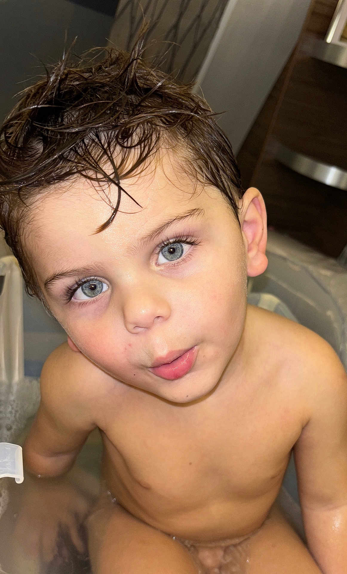 Silas participe au concours pour gagner de l'argent avec cette photo : child, toddler, bathtub, bath, water, wet_hair, blue_eyes, skin, face, expression, curious, indoors, plumbing, bathroom, young_child, person, cute, sitting, closeup, portrait