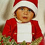 Silas a rejoint le concours — aidez-le/la à gagner de superbes lots ! child, toddler, santa_hat, red_clothing, christmas_decorations, holiday, festive, greenery, ornaments, face, portrait, cute, holiday_season, celebration, indoors, young_child, costume, holiday_outfit, seasonal, festivity