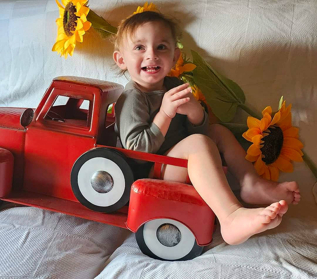 Skyler joined the competition — help win amazing prizes! arm, automotive_design, automotive_tire, car, eye, face, hand, head, human_body, joy, leg, motor_vehicle, orange, organ, person, smile, tire, toy, vehicle, wheel